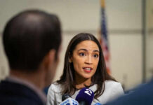 Woman speaking to journalists with microphones nearby