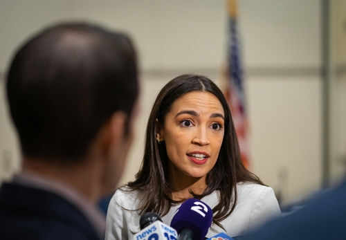 Woman speaking to journalists with microphones nearby