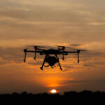 A drone flying against a sunset background