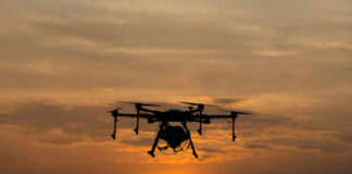 A drone flying against a sunset background
