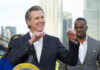 Newsom’s Bold Move: Trolling Trump for Power Person speaking at podium with others in background