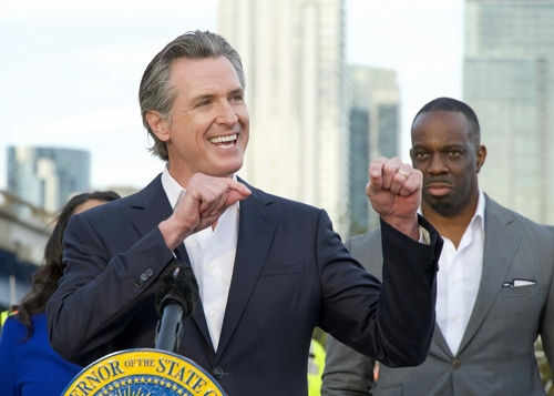 Person speaking at podium with others in background