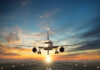 Airplane landing on runway during sunset sky