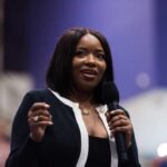 A woman speaking into a microphone at a conference