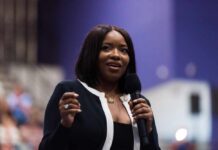 A woman speaking into a microphone at a conference