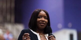 A woman speaking into a microphone at a conference