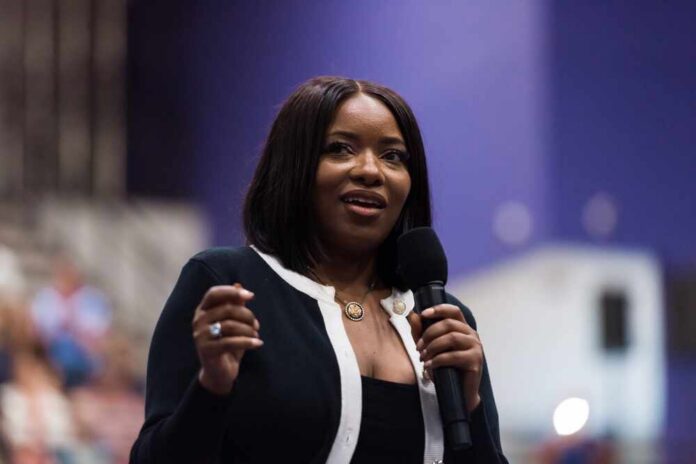 shutterstock_2682332437.jpg A woman speaking into a microphone at a conference