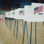 Voting booths lined up in a gymnasium.