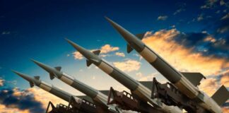 Cruise missile launcher with missiles pointed upwards against a sunset sky