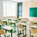 Empty classroom with desks facing a chalkboard