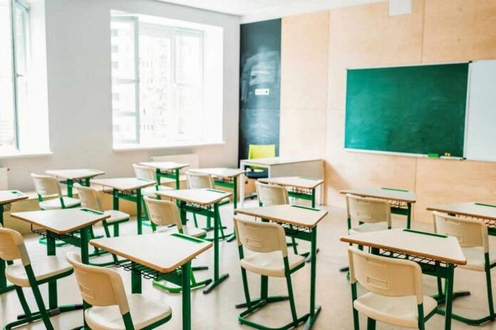Empty classroom with desks facing a chalkboard