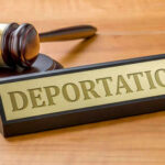 Gavel and sign reading Deportation on desk.
