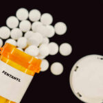 Prescription bottle of fentanyl tablets scattered on surface