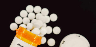 Prescription bottle of fentanyl tablets scattered on surface