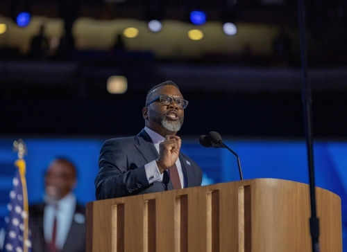 Man speaking at podium on stage with microphone