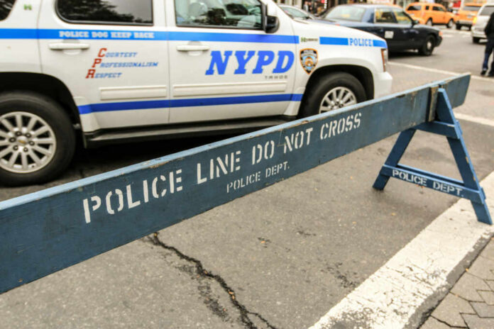NYPD police barricade on city street with vehicles