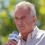 Man speaking into microphone at outdoor event