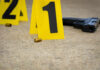Crime scene with evidence markers gun and bullet casings