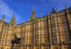 The Houses of Parliament in London with a statue in the foreground