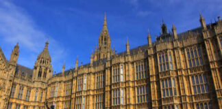 The Houses of Parliament in London with a statue in the foreground