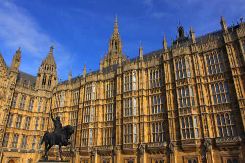 The Houses of Parliament in London with a statue in the foreground
