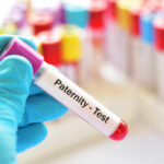 Hand holding a blood sample labeled for a paternity test