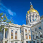 Historic government building with a golden dome under a blue sky