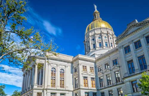 Historic government building with a golden dome under a blue sky
