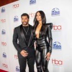 A celebrity couple posing on the red carpet at an awards event