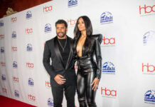 A celebrity couple posing on the red carpet at an awards event