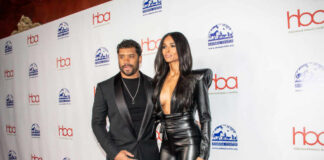 A celebrity couple posing on the red carpet at an awards event