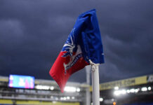 Corner flag of Crystal Palace F.C. at a stadium under dark clouds