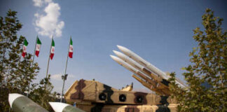 Military missiles displayed outdoors with Iranian flags in the background