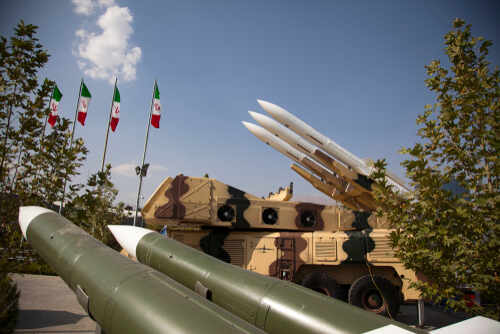 shutterstock_1621002838.jpg Military missiles displayed outdoors with Iranian flags in the background