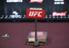 UFC weighing scale with promotional signage in the background