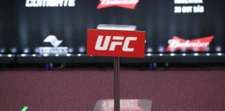 UFC weighing scale with promotional signage in the background
