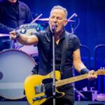 A musician passionately performing on stage with a guitar