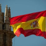 Spanish flag waving against a clear blue sky