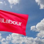 Red flag with 'Labour' text flying against a cloudy sky