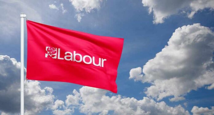 Red flag with 'Labour' text flying against a cloudy sky