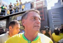 A man in a yellow shirt surrounded by a crowd at a political rally