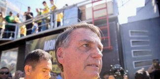 A man in a yellow shirt surrounded by a crowd at a political rally