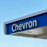 Chevron gas station sign against a clear blue sky