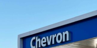 Chevron gas station sign against a clear blue sky