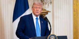 Donald Trump delivering a speech at a podium in the White House