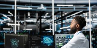 A man working at a computer workstation with multiple screens displaying data visualizations