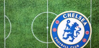 Chelsea Football Club logo on a soccer field background