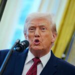 A man speaking into a microphone during a public address