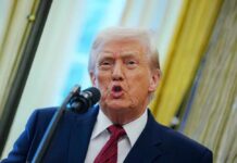 A man speaking into a microphone during a public address