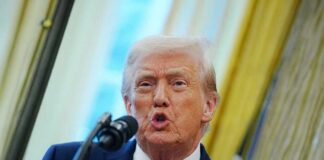 A man speaking into a microphone during a public address